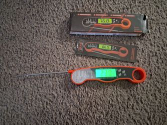 digital instant-read meat thermometer featuring a bright orange casing, foldable stainless steel probe, and backlit digital display