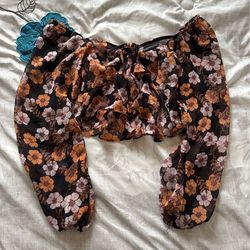 Black long sleeve crop top with orange and white floral patterns