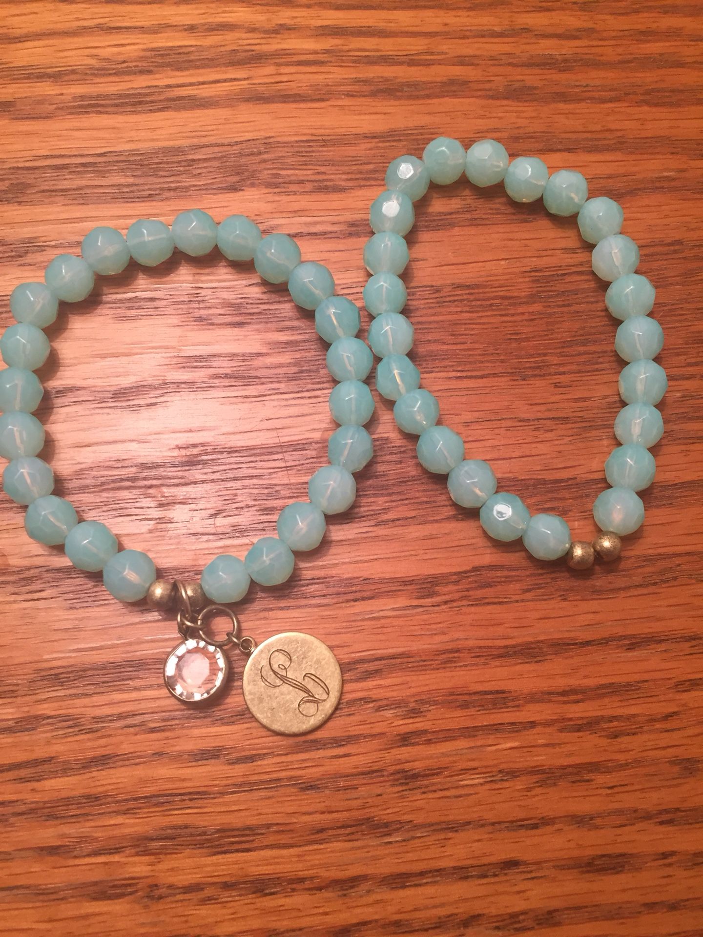 2 Beaded Stretch Bracelets. One has 2 charms