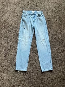 Light blue wash straight leg jeans with distressed detailing at the knees