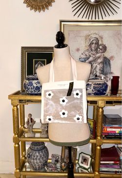 Christian Siriano's elegant translucent mesh tote bag stands out for its delicate black and white floral appliqués.