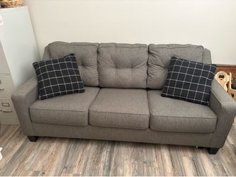 Grey couch sleeper sofa with black pillows