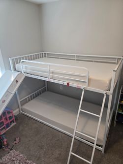 White twin over twin bunk bed with slide ladder and mattresses