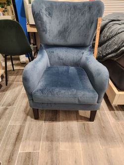 Chair blue velvet wingback chair a distinctive curved high back.
