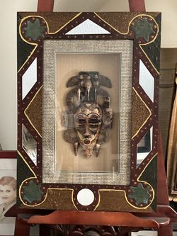 Mask framed under glass in a shadowbox