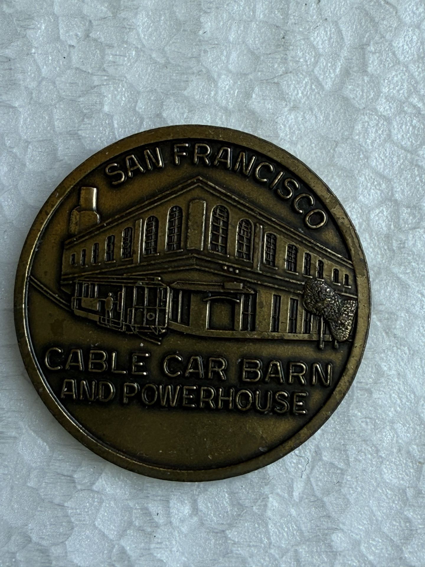 Bronze souvenir coin featuring the San Francisco Cable Car Barn and Powerhouse.