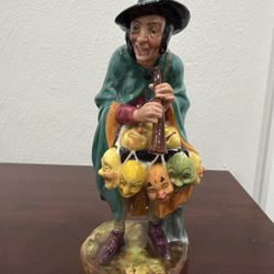 Royal Doulton porcelain figurine, specifically the "The Mask Seller" (HN 2103).  