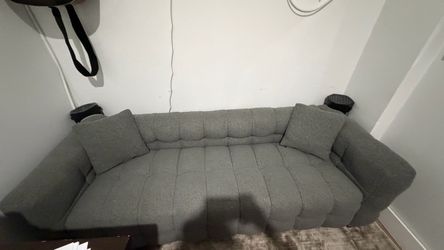 gray teddy fleece sofa featuring a vertical channel-tufted wave pattern and matching throw pillows