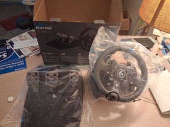 New Logitech G923 racing wheel and pedals set. This black racing peripheral has TRUEFORCE high-definition force feedback technology. It is compatible 