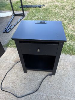 Nightstand With an Integrated charging station featuring USB ports and standard outlets