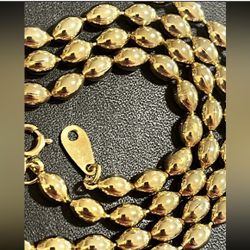 Elegant polished gold-tone bead chain. Smooth, reflective beads create a classic and versatile look. Perfect for layering or wearing alone for a refin