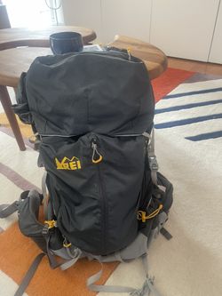 Selling a brand-new REI Flash 65 backpack in Asphalt color, size Medium (65 liters). • Never used – tags still attached • Lightweight internal frame