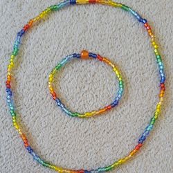 handmade rainbow-colored beaded necklace and matching bracelet set made with beads and elastic cord.