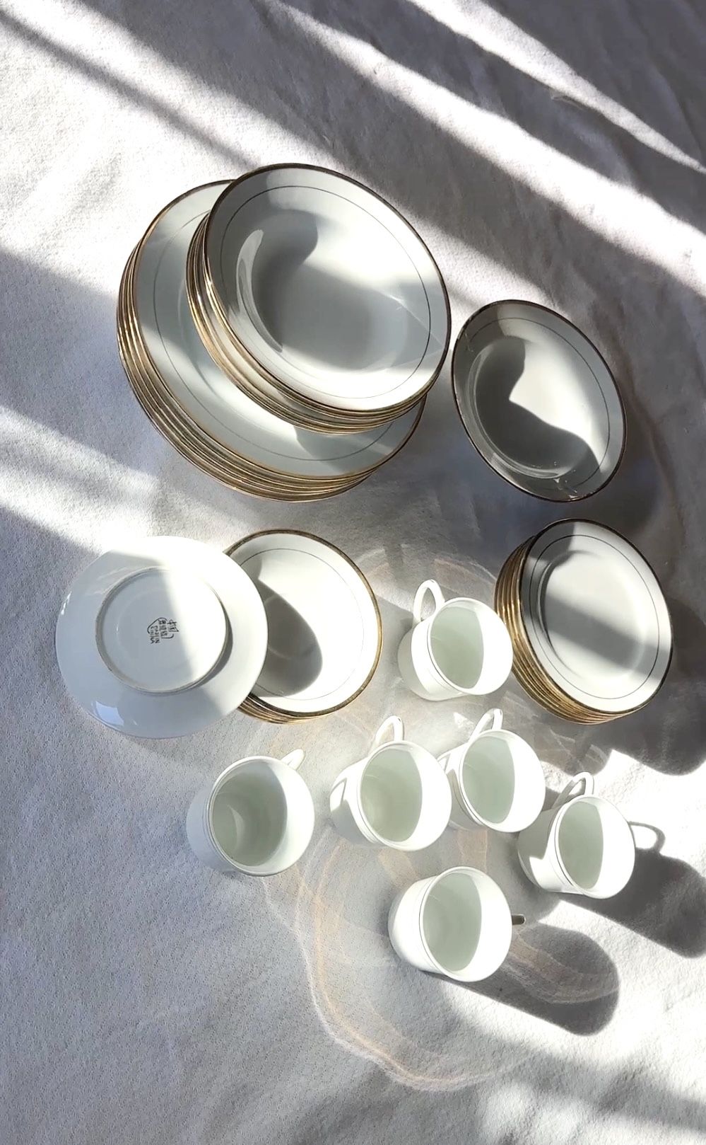 white porcelain plate with a gold rim and a manufacturer's mark In Chinese 