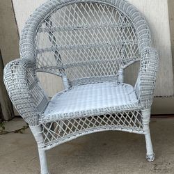 White wicker accent chair with an open lattice back and airy, lightweight design