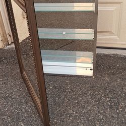 rectangular wall mirror with a bronze or oil-rubbed bronze finish frame. The frame has a classic