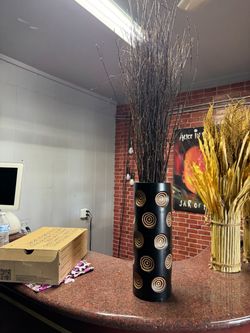 Tall black carved vase with decorative branches