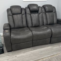 Reclining loveseat with cupholders and storage in the armrest has LED lights and chargers for phones