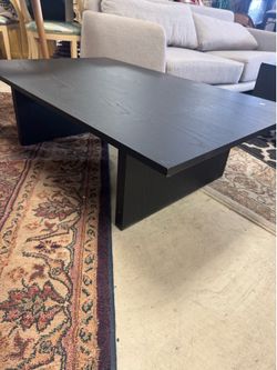 Modern black rectangular coffee table in a modern minimalist style with a paneled wood base - 47” x 30” x 14”