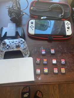 Nintendo Switch OLED in great condition. Includes carrying case, wireless controller, Joy-Con grip, and 10 games including Mario Kart 8, Smash Bros Ul