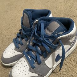 Youth Nike Air Jordan 1 Mid shoe in the "Cement Grey/White-True Blue" colorway