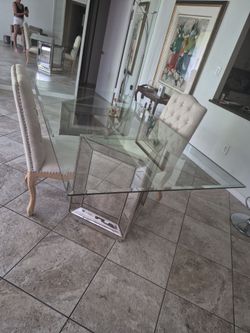 4 ft by 7 ft glass and beveled, mirrored table with 6 upholstered chairs, like new, no scratched, no chips. Elegant.