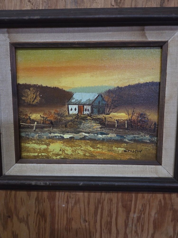 framed oil painting of a rural landscape, signed "WOODSON" in the bottom right corner.