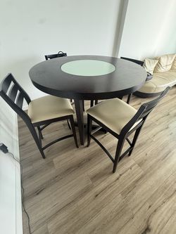 High top dining table wth four leather chairs