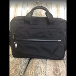 TUMI Briefcase. Brand new. Black. 15” by 12” by 6”.