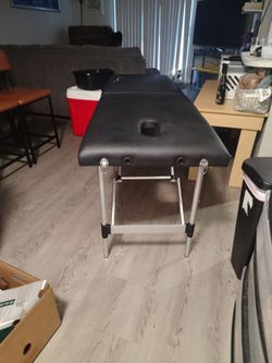 Foldable black leather massage table