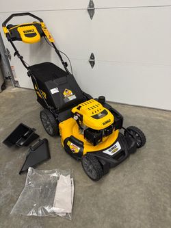 DeWalt RWD self-propelled gas lawn mower in yellow and black. Includes rear bag, side discharge chute, and documentation. All original tags still atta
