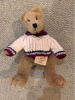 Vintage teddy bear wearing sweater.