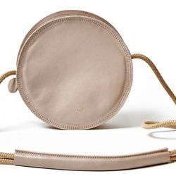Elevate your style with this chic beige round crossbody bag. Perfect for any occasion, this bag combines elegance and functionality.  New without tags