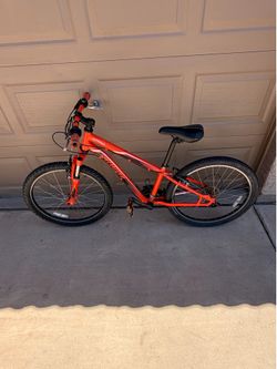 This is a red Specialized Hotrock 24-inch kid's mountain bike -