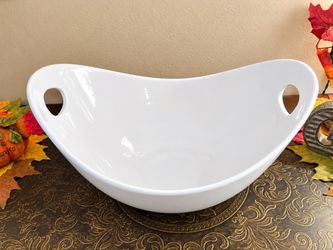 Heavy white ceramic or porcelain serving bowl with integrated cut-out handle slots