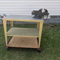 Solid steel heavy duty vise mounted to steel table with aluminum top and caster wheels with locks. This vice is NOT cast steel. It is in excellent con