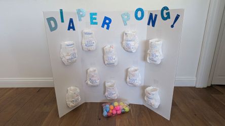 Diaper pong board with ping pong balls