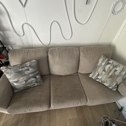 grey love seat couch with pillows