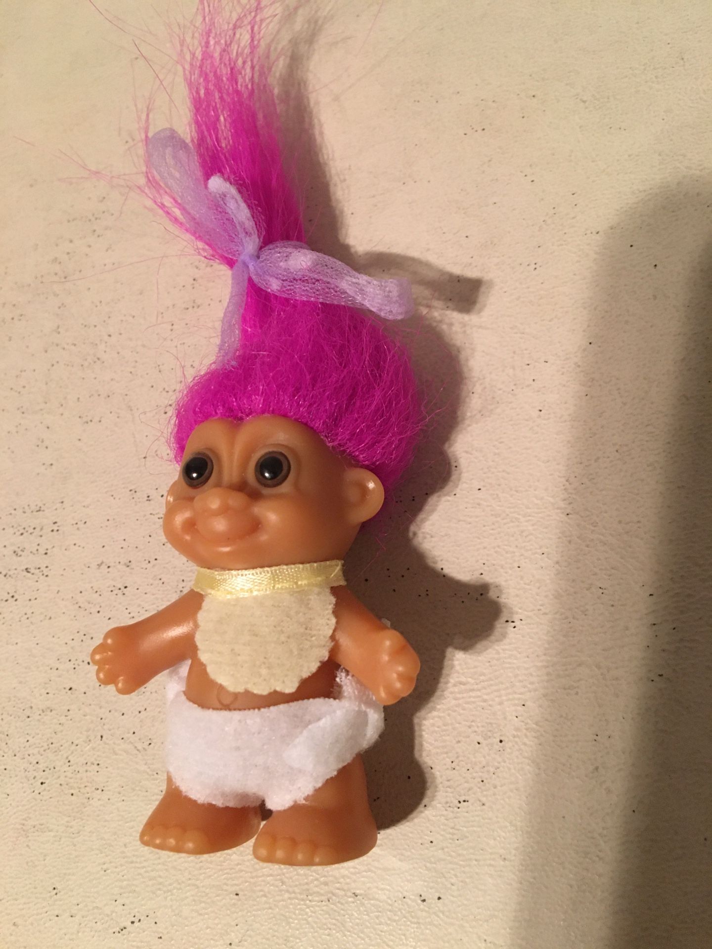 2 inch baby troll wearing bib and diaper, 5 inches including hair