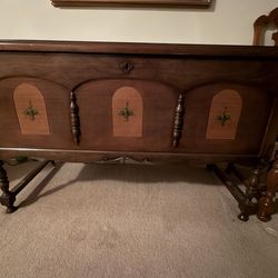 Vintage wooden cedar chest with decorative arched panels and carved legs.