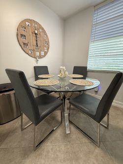 modern contemporary round glass-top table with a chrome geometric base