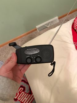 Solar and crank powered radio with flashlight