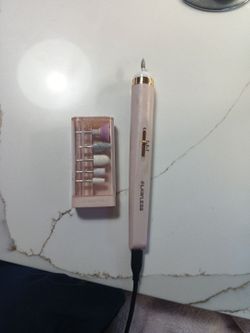 Finishing Touch Flawless Salon Nails rechargeable manicure device in pink, featuring a precision control design.The set includes 6 interchangeable att