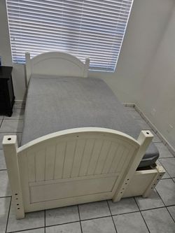 White wooden single bed with storage space