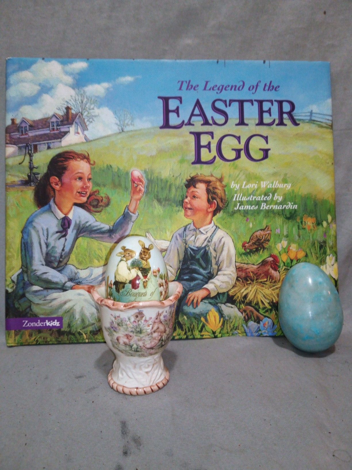 Easter egg holder with marbale rock egg and book