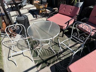 Outside metal table with glass and two chairs