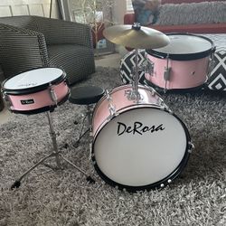Great condition kids pink drum set.  Has snare drum, stool, cymbal, as well kick for kick drum.  Works great!  Great set!  Doesn’t sound like a toy li