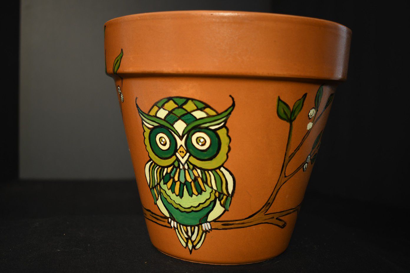 Cute owl on flowering tree terracotta pot