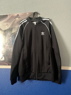 This is an Adidas Originals SST Track Jacket in black with signature white stripes