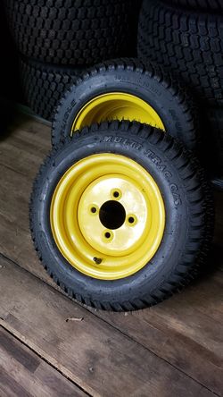Pair of 18x8.50-10 Carlisle Multi Trac C/S lawnmower tires on JD yellow 4-lug wheel